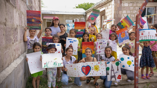 Sarigyugh’s children show their paintings after a session with Armenie, Terre de Vie participants.